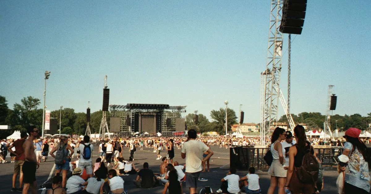 Foule profitant d'un festival de musique d'été en plein air par une journée ensoleillée.
