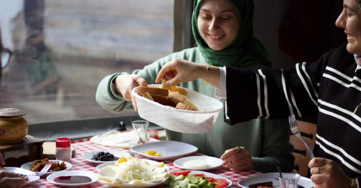 Un groupe d'amis partageant un petit-déjeuner traditionnel à l'intérieur, composé de plats variés et dans une chaleureuse ambiance conviviale.